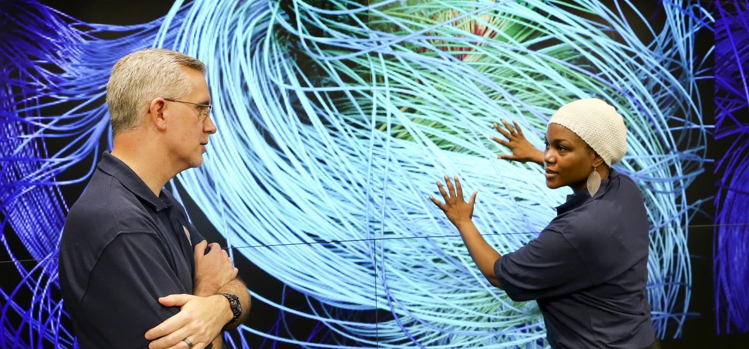 Scientists discuss a simulation in the EVEREST visualization theater of the Oak Ridge Leadership Computing Facility.