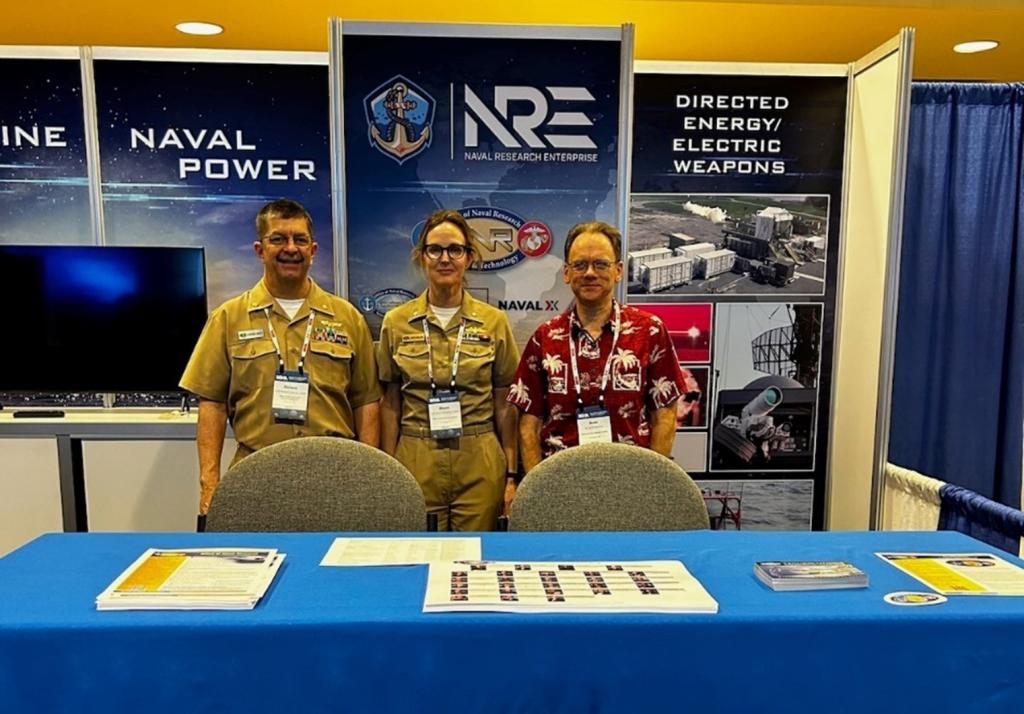 LCDR Rich Harvey, pictured on the left, poses with two colleagues at the 2023 POST Conference. Credit: Rich Harvey