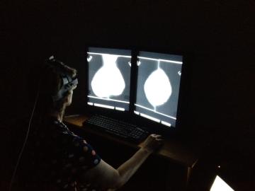 A radiologist outfitted with the team’s head-mounted eye-tracking device examines a mammogram. Credit: Hong-Jun Yoon/Oak Ridge National Laboratory, U.S. Dept. of Energy