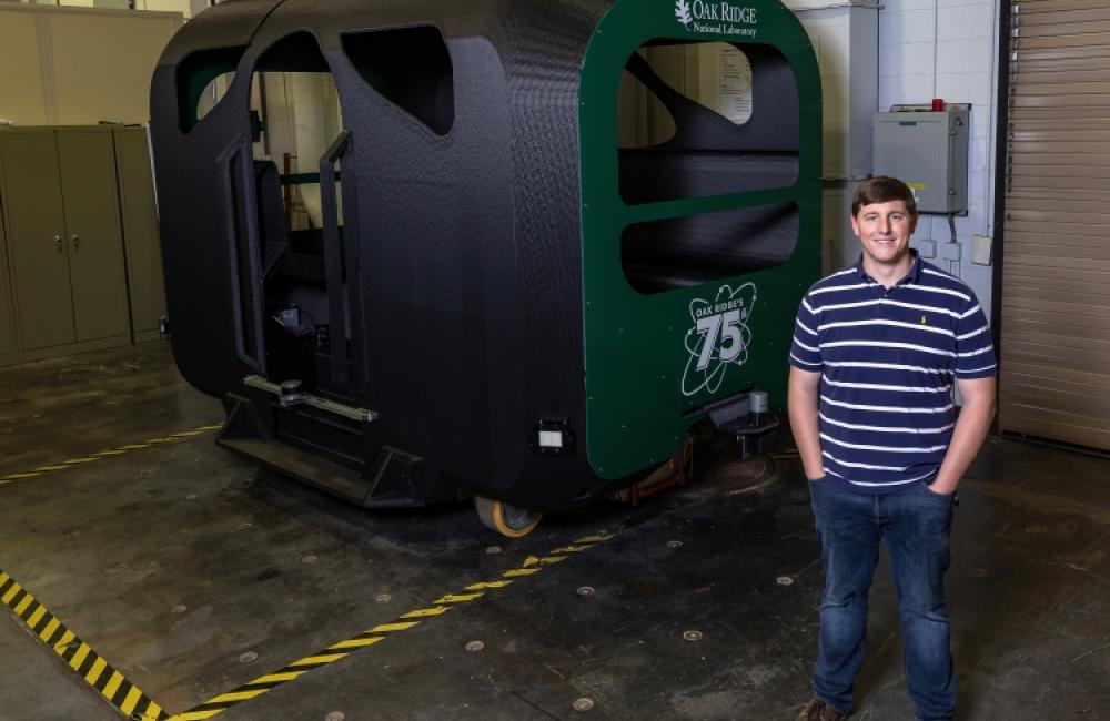 Dean Deter standing in front of small 3d Printed bus 