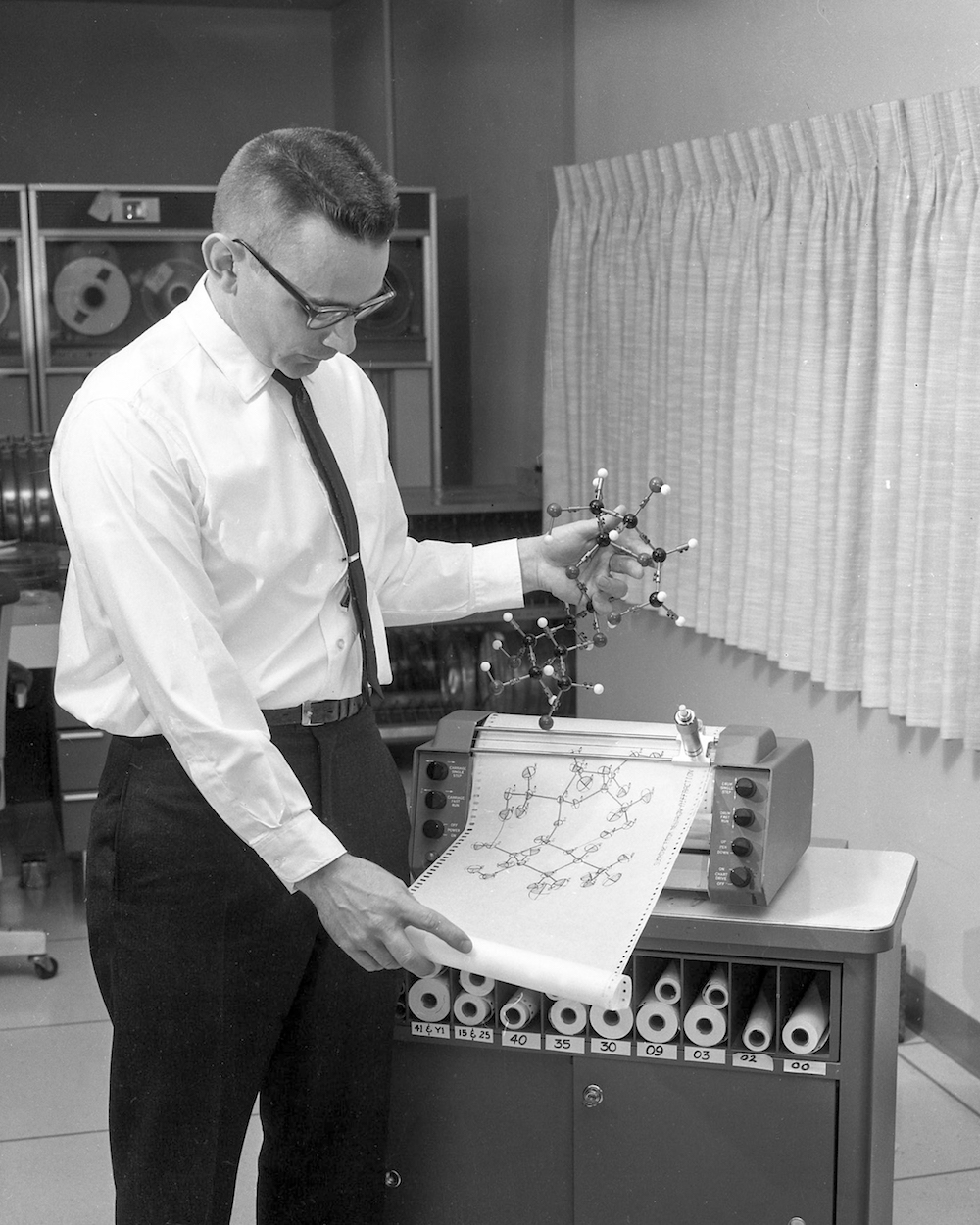 ORTEP developer Carroll K. Johnson compares a computer-generated three-dimensional illustration of the crystal structure of table sugar to a ball-and-stick three-dimensional model.