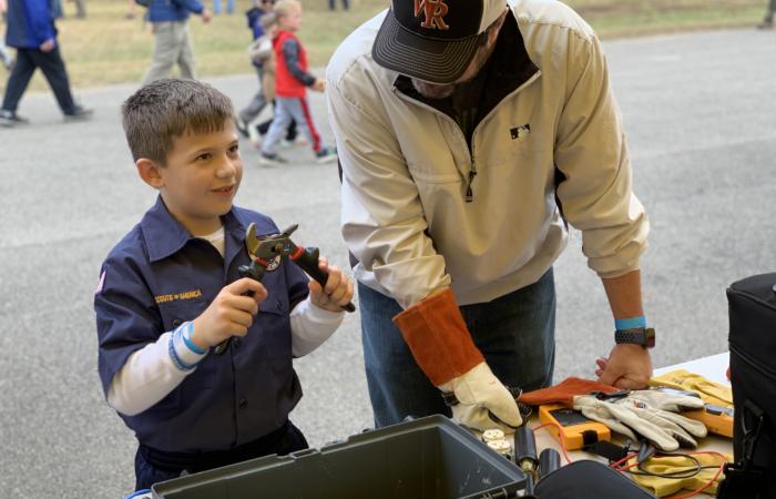 Liam Robinson, 7, from Knoxville Cub Scout Pack 346, checked out a display of home electrical wiring and picked up a pair of high-voltage-rated channel locks at the Facilities & Operations exhibit staffed by electrician Jonathan Crowley. “He was picking up stuff … and loving every bit of it,” said Liam’s father, Will Robinson.