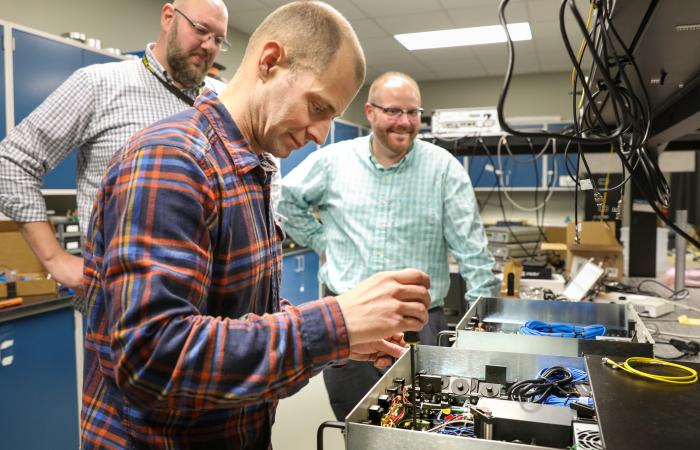 ORNL quantum researchers (from left) Brian Williams, Phil Evans and Nick Peters work on their QKD system. Image credit: Genevieve Martin/Oak Ridge National Laboratory, U.S. Dept. of Energy