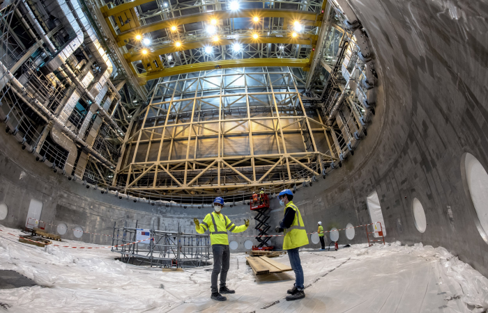 ITER staff inside the “dish” of the cryostat base. The 1250 ton base will initially be lifted just a few centimeters in preparation for its transfer to the tokamak pit. Photo: ITER Organization