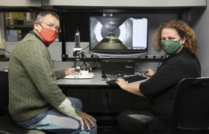 ORNL researchers Reinhard Boehler, left, and Bianca Haberl demonstrate the improved pressure cell developed by Boehler. The devise uses two gem-quality synthetic opposing diamonds to exert extreme pressures on materials. Credit: Genevieve Martin/ORNL, U.S. Dept. of Energy
