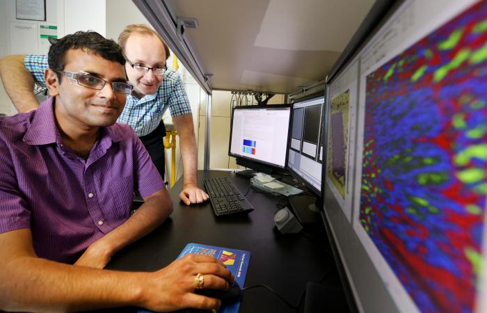 ORNL’s Sergei Kalinin and Rama Vasudevan (foreground) use scanning probe microscopy to study bulk ferroelectricity and surface electrochemistry -- and generate a lot of data. Credit: Jason Richards/ORNL, U.S. Dept. of Energy