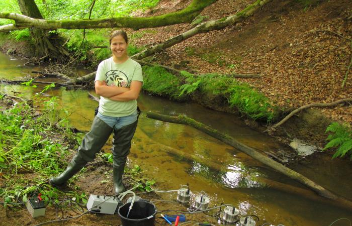 Marie Kurz calibrates fluorometers to measure tracer concentrations at a lowland stream in West Sussex, UK, in 2015. The data was later used by ORNL scientists to validate models of stream transport. Credit: Jay Zarnetske
