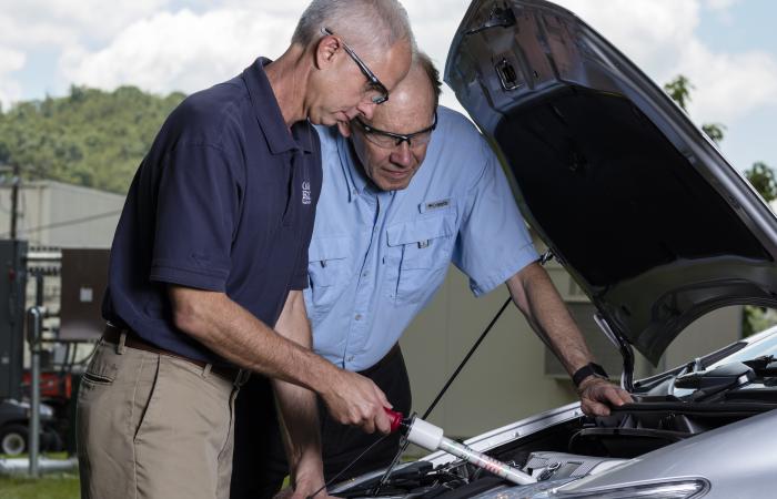 Nance Ericson, left, and Bruce Warmack of ORNL test the DC hotstick on a hybrid electric vehicle. Credit: Carlos Jones/Oak Ridge National Laboratory, U.S. Dept. of Energy.