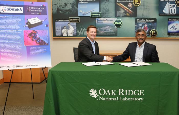 Qubitekk’s Duncan Earl (left) signed a non-exclusive licensing agreement with ORNL Laboratory Director Thomas Zacharia for ORNL’s invention that produces quantum light particles, known as photons, in a controlled, deterministic manner that promises 