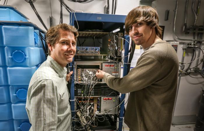 From left, Jason Newby of ORNL and Brandon Becker of the University of Tennessee–Knoxville examine equipment that will collect data for COHERENT. Becker, a graduate student, will model, simulate and analyze interesting physics that result from interaction