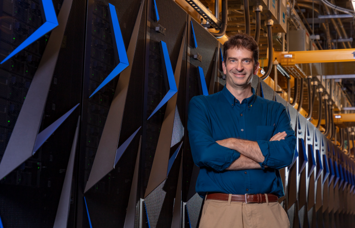 Tom Karnowski, shown here with the Summit supercomputer, is leading a team of scientists using high performance computing to improve mobility and increase fuel efficiency in an HPC4Mobility project at ORNL. 