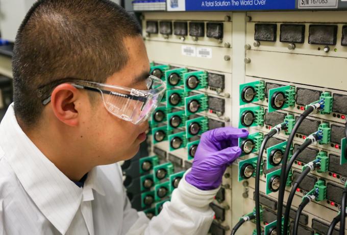 Ronnie Tao tests a coin cell battery as part of an effort to advance energy storage materials.