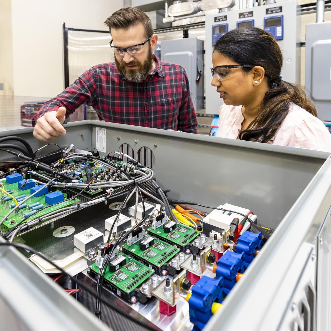 Steven Campbell and Radha Krishna-Moorthy discuss part of the power electronics that make up the Smart Universal Power Electronics Regulator technology developed at ORNL. Credit: Carlos Jones/ORNL, U.S. Dept. of Energy