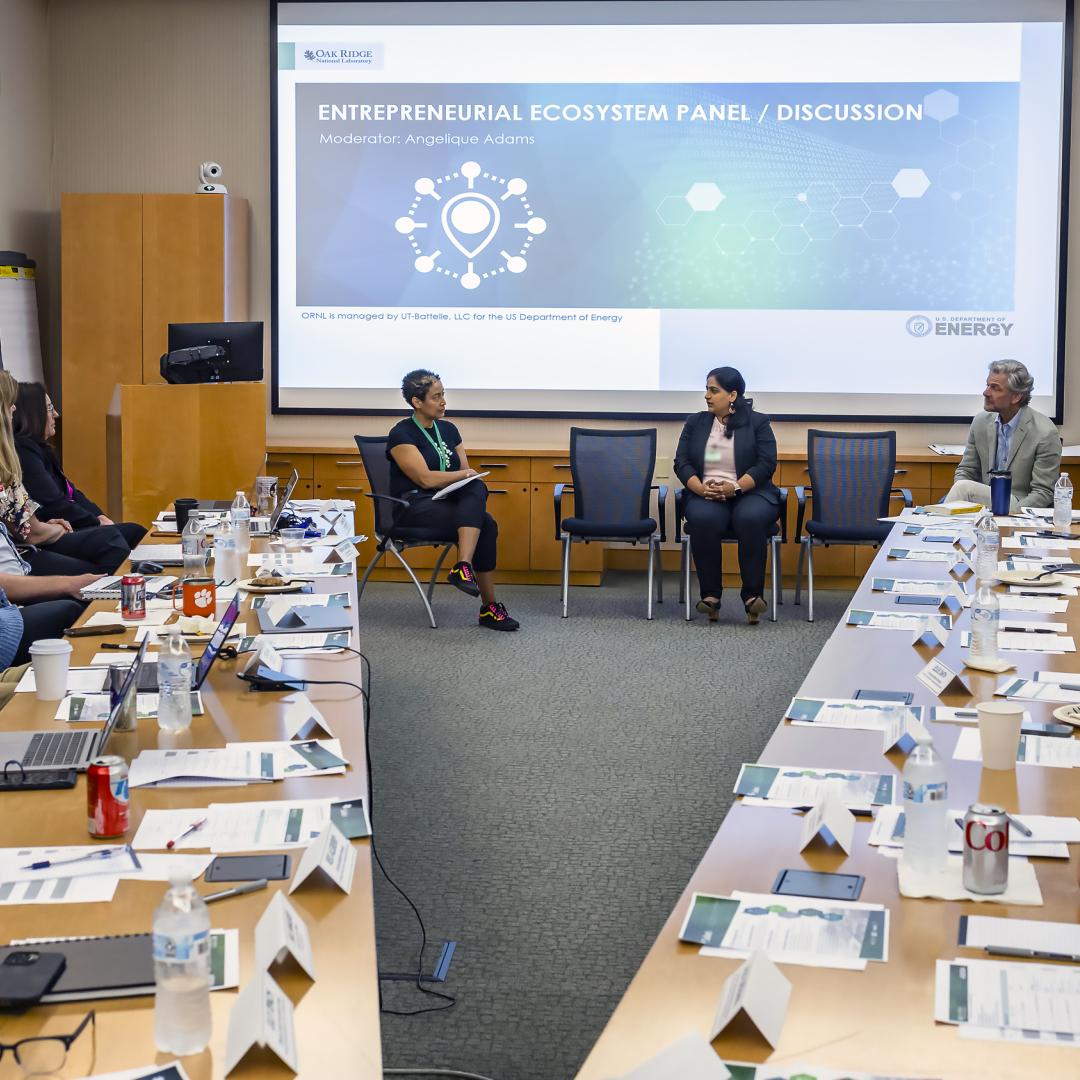 Angelique Adams, front left, introduces Kusum Rathore, front center, executive director and vice president of the multi-campus office at the University of Tennessee Research Foundation, and Jim Biggs, executive director of the Knoxville Entrepreneur Center, during the final presentation event for ORNL’s Safari coaching program. 