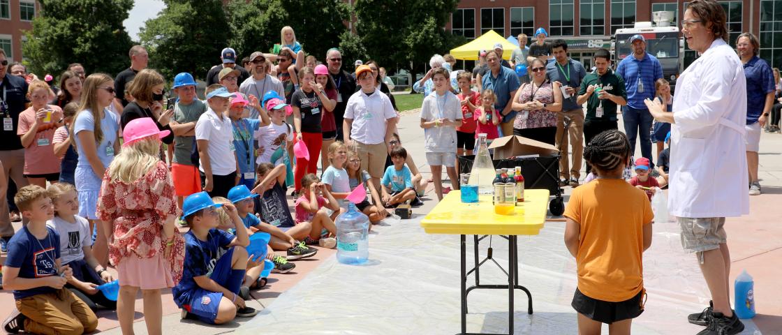 Group of children watching a live science demonstration.