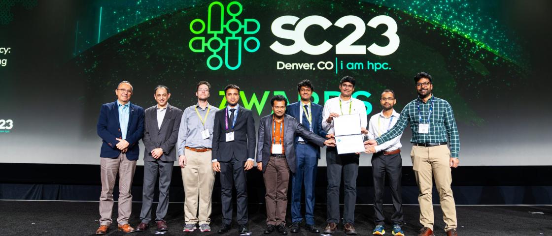 Group of people accepting an award in front of SC23 banner.