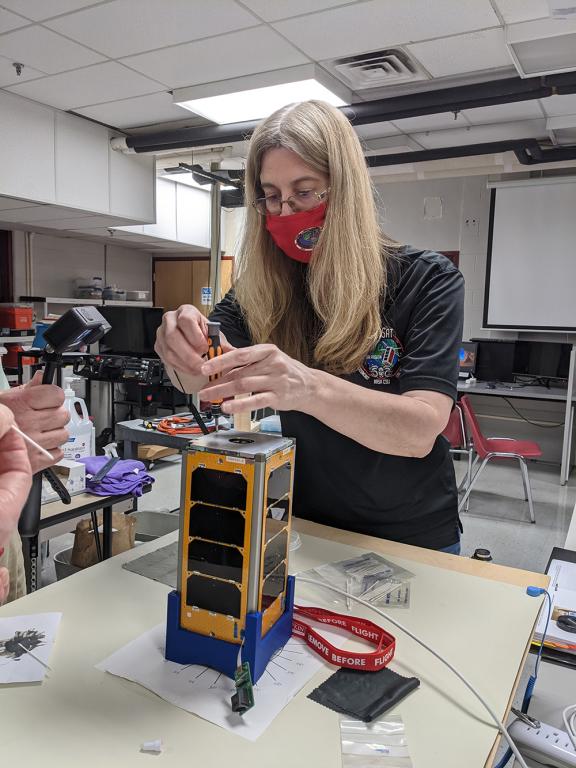 ORNL's Melissa Dumas attaches the top panel of RamSat during the final assembly stage. Credit: Ian Goethert/ORNL, U.S. Dept. of Energy