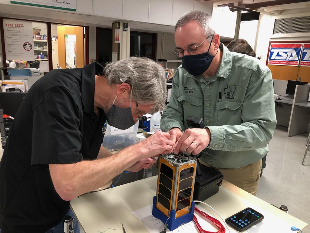 ORNL's Peter Thornton and volunteer technical mentor David Andrews work together to prepare RamSat. Credit: Ian Goethert/ORNL, U.S. Dept. of Energy