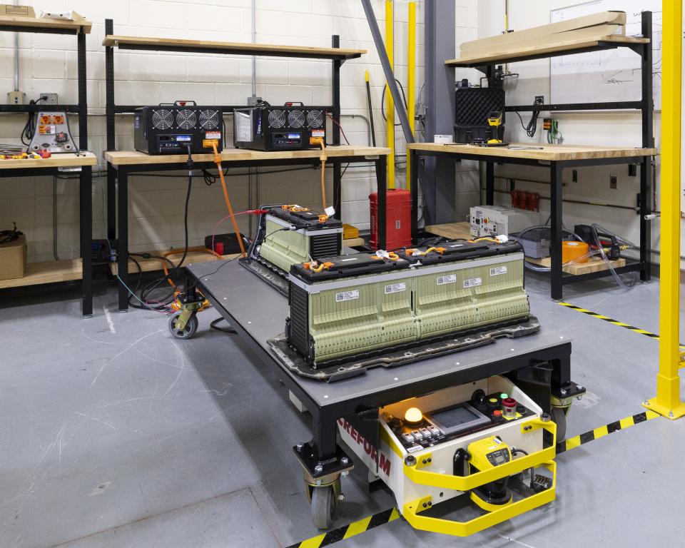 EV batteries on a remote-controlled portable platform plugged into electrical equipment in a lab