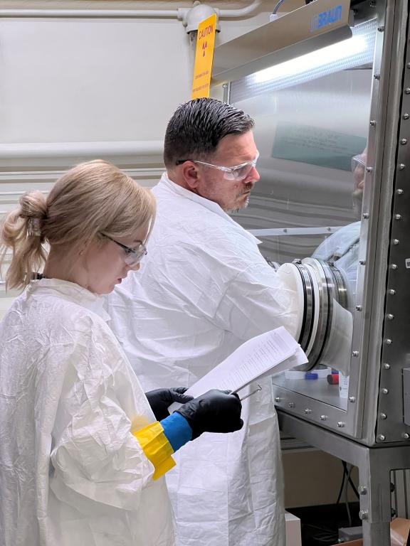 Setzer and teammate Lance Wyant work at a glovebox. Credit: Allison Peacock/ORNL, U.S. Dept. of Energy