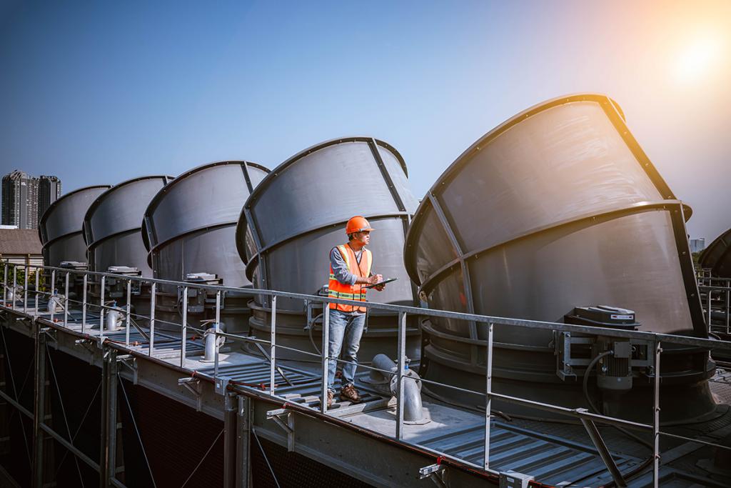 Engineer under checking the industry cooling tower air conditioner is water cooling tower air chiller HVAC of large industrial building to control air system.