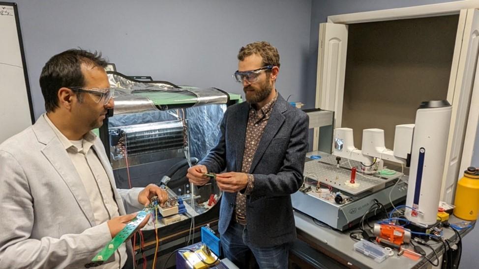 ORNL’s Kyle Gluesenkamp, right, confers with Ayyoub Momen, founder and chief executive officer of Ultrasonic Technology Solutions and a former ORNL researcher. Gluesenkamp helped Momen and ORNL’s tech transfer personnel successfully transition the ultrasonic drying technology from the lab to the commercial sector. Gluesenkamp has been named Outstanding Researcher by the Federal Laboratory consortium. Credit: ORNL, U.S. Dept. of Energy