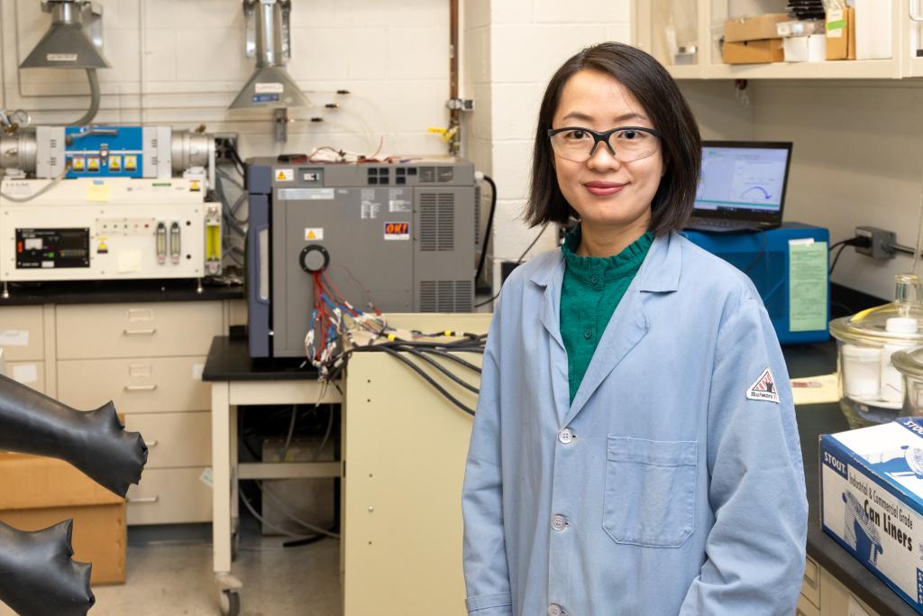 Chelsea Chen, polymer physicist at ORNL, stands in front of an eight-channel potentiostat and temperature chamber used for battery and electrochemical testing. Credit: Genevieve Martin/ORNL, U.S. Dept. of Energy