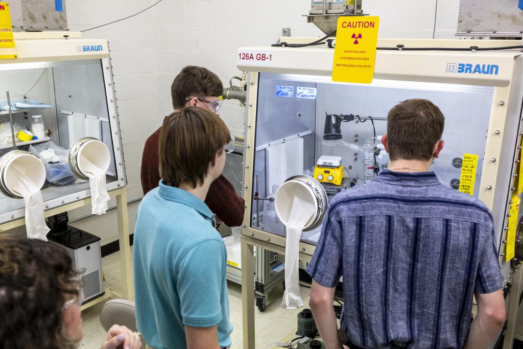 Pellissippi State students, from left, Hayden Presley, Jared Dowell and Jon Rowland examine a glovebox in the Radiochemistry Laboratory, as group leader Allison Peacock looks on. Credit: Carlos Jones/ORNL, U.S. Dept. of Energy