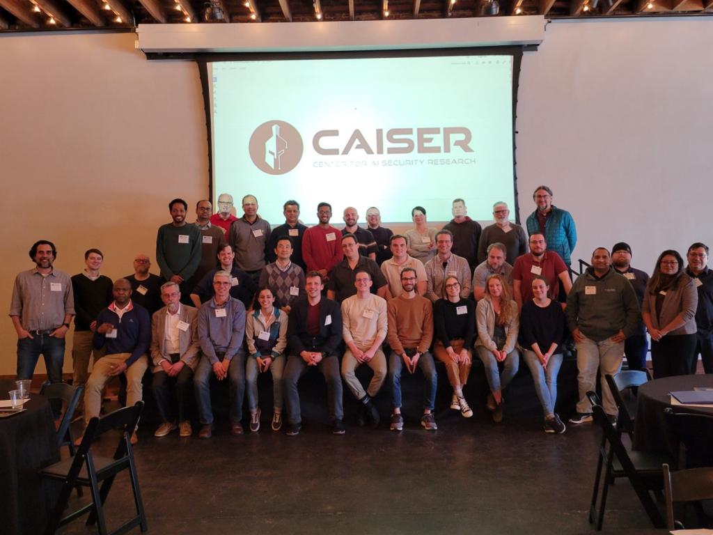 Caption: Participants gather for a group photo after discussing securing AI systems for critical national security data and applications. Photo by Liz Neunsinger/ORNL, U.S. Dept. of Energy