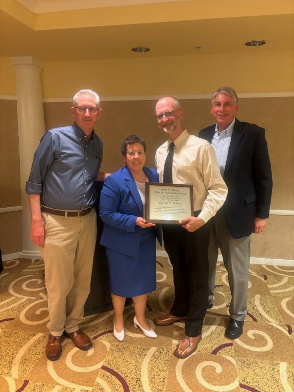 Lætitia Delmau, left center, receives the national Glenn T. Seaborg Actinide Separations Award from Idaho National Laboratory’s Peter Zulupski, right center, at the 47th Actinide Separations Conference, for which Zulupski was chair. Looking on are two previous award recipients, Greg Lumetta of Pacific Northwest National Laboratory, left, and Tracy Rudisill of Savannah River National Laboratory, right. 