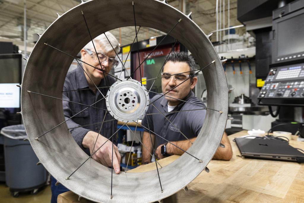 two researchers examining a 3D printed wheel