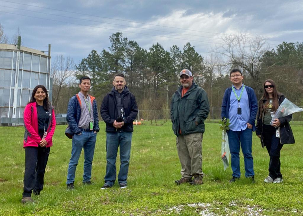 6 researchers pose in a field during an overcast day