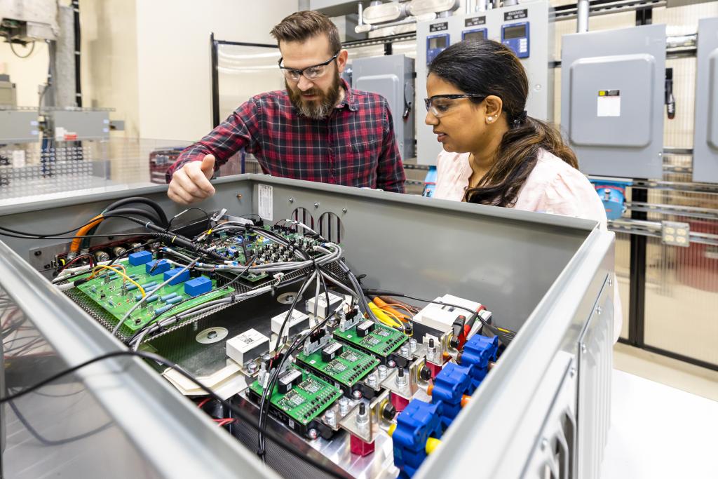 Two researchers discussing a circuit board