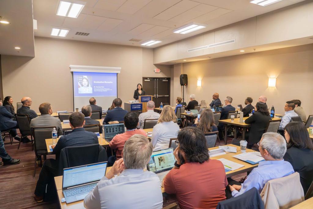 Big group of people in a room listening to a presentation. 