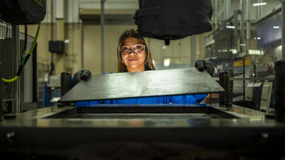 Researcher Brittany Rodriguez positions a test piece created as part of her research on polymer joining with thermoplastics. Credit: Carlos Jones/ORNL, U.S. Dept. of Energy