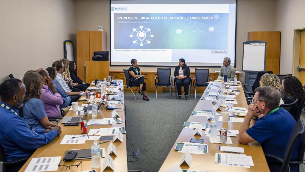 Angelique Adams, front left, introduces Kusum Rathore, front center, executive director and vice president of the multi-campus office at the University of Tennessee Research Foundation, and Jim Biggs, executive director of the Knoxville Entrepreneur Center, during the final presentation event for ORNL’s Safari coaching program. 