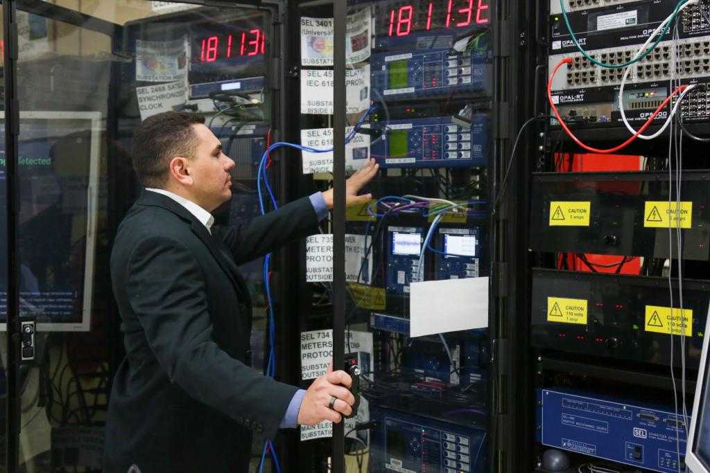 Man changing settings on electrical substation equipment in a lab