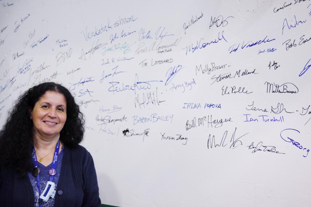 ORNL’s Hassina Bilheux stands before names of staff who have worked on the Spallation Neutron Source’s latest addition, VENUS. 