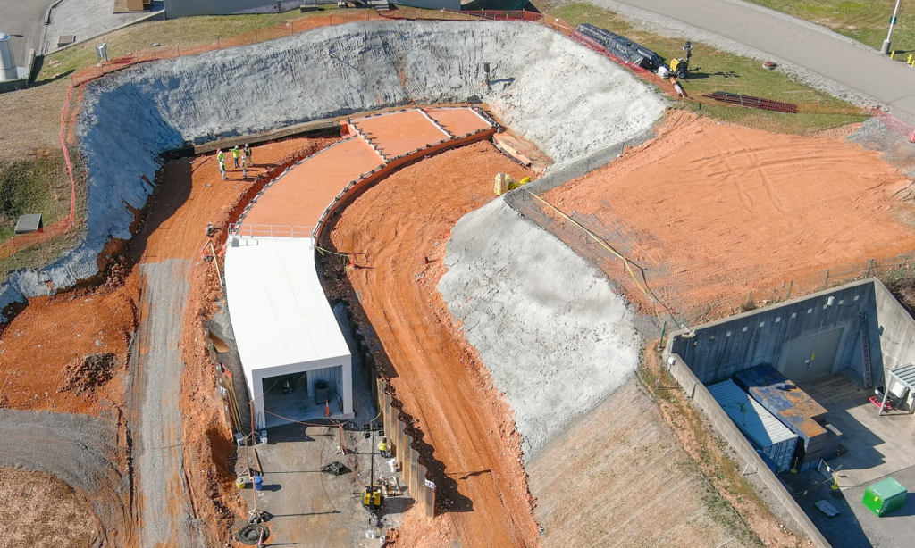 In preparation for building the new tunnel section, workers removed about 20,000 cubic yards of dirt, weighing more than 40 million pounds, to expose where the extension would connect to the existing SNS beam transport tunnel. Credit: ORNL, U.S. Dept. of Energy