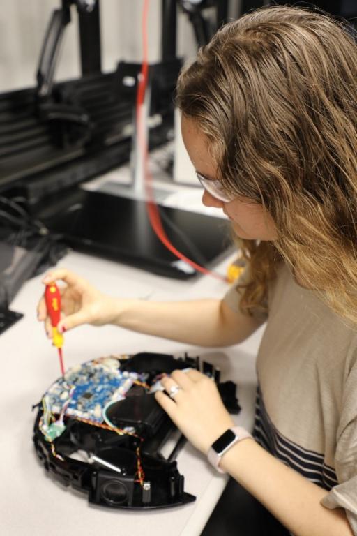 During her summer internship at ORNL, Abigail Baker is researching potential vulnerabilities in a robot vacuum. Credit: Josie Fellers/U.S. Dept. of Energy