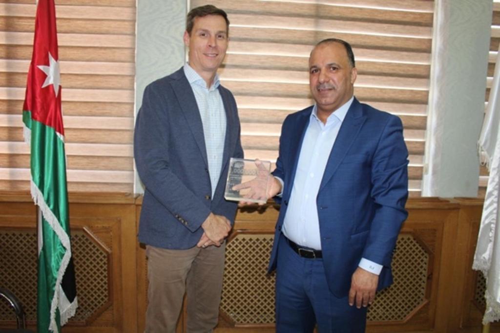 Ray Greenberg, federal program manager for DOE’s NSDD relationship with Jordan, presents engineer Ziad Al-Saida, right, with a plaque honoring the one billionth item scanned by radiation portal monitors