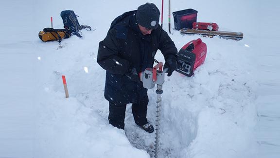 Alex Kholodov (University of Alaska, Fairbanks) uses an electric auger to prepare holes for water wells at NGEE Arctic Sites in Barrow, Alaska