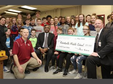 ORNL Director Thomas Zacharia (center, seated) visited Robertsville Middle School to present a check in support of the school’s CubeSat efforts. 