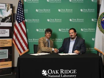 ORNL Director Thom Mason (left) and Thomas Roberts of Oddello Industries LLC sign a research and development agreement.