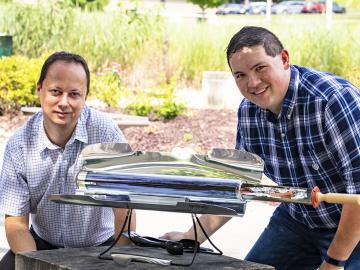 From left, Radu Custelcean and Neil Williams of Oak Ridge National Laboratory used a solar-powered oven to generate mild temperatures that liberate carbon dioxide trapped in guanidine carbonate crystals in an energy-sustainable way. From left, Radu Custelcean and Neil Williams of Oak Ridge National Laboratory used a solar-powered oven to generate mild temperatures that liberate carbon dioxide trapped in guanidine carbonate crystals in an energy-sustainable way.