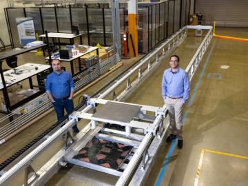 L-R: ORNL’s Omer Onar and Veda Galigekere with the dynamic wireless charging test bed at ORNL’s Grid Research Integration and Deployment Center. Credit: Carlos Jones, ORNL/U.S. Dept. of Energy