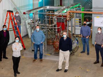 A team of fusion scientists and engineers stand in front of ORNL’s Helium Flow Loop device. From back left to front right: Chris Crawford, Fayaz Rasheed, Joy Fan, Michael Morrow, Charles Kessel, Adam Carroll, and Cody Wiggins. Not pictured: Dennis Youchison and Monica Gehrig. Credit: Carlos Jones/ORNL.