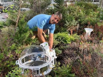 Oak Ridge National Laboratory’s Dave Weston works in a chamber at the DOE SPRUCE whole ecosystem experiment site in the peatlands of northern Minnesota. Credit: Kyle Pearson/ORNL, U.S. Dept. of Energy