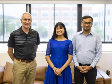 Lab director Jeff Smith (left) congratulates Nia Maheshwari (center), daughter of Ketan (right) and Archana Maheshwari, on being named the recipient of the 2023 UT-Battelle Scholarship. Ketan Maheshwari is an engineer in the lab's Computing and Computational Sciences Directorate.