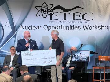 During the Nuclear Opportunities Workshop on August 2, UT-Battelle’s Jeff Smith presented Roane State President Chris Whaley with a $100,000 check to help launch a Nuclear Technology Program at the college. Credit: ORNL, U.S. Dept. of Energy
